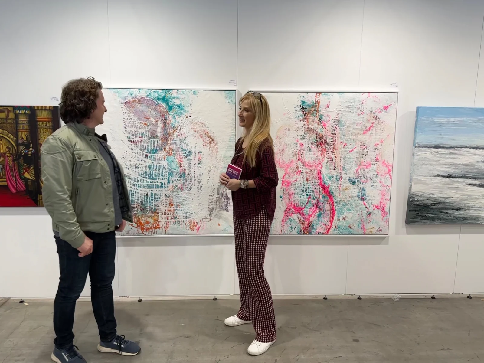 Barbara Eder im Gespräch vor zwei ihrer Gemälde auf der Discovery Art Fair in Köln.